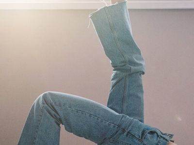 Silhouette of a person in a deep stretching pose against a window.